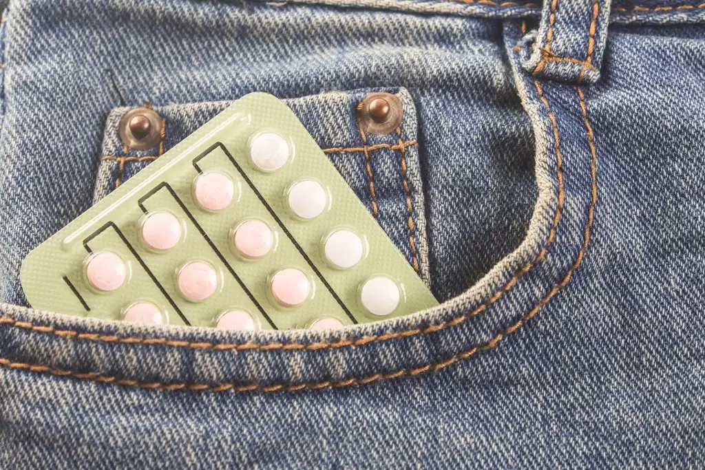 Birth control pill packet in denim jean pants pocket