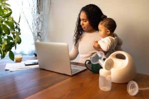 women holding baby with breast pump in foreground