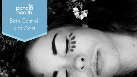 Close-up of girl's face lying in grass with flower in hair