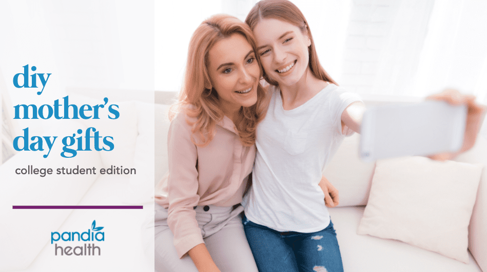 mother and daughter sitting on white couch as daughter, perched on mom's lap, takes a selfie of them