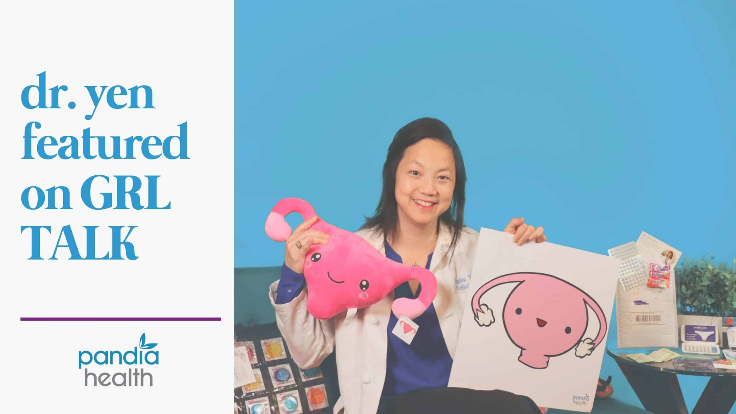 female doctor smiling sitting on couching a uterus pillow in left hand and poster of cartoon uterus in right hand