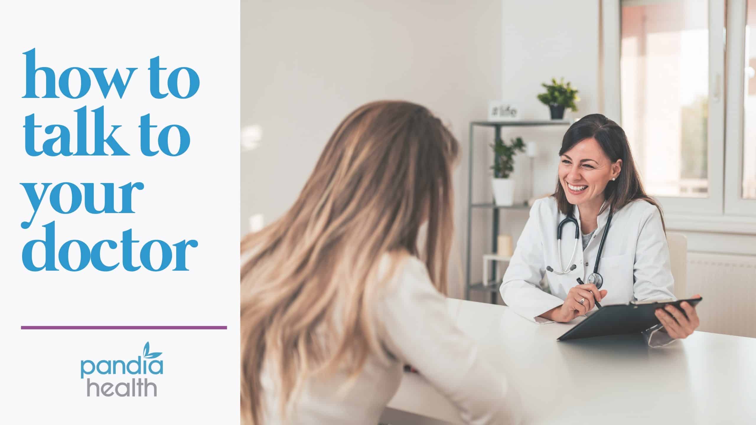 female patient talking to female doctor across a desk in a white room