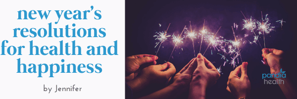 group of hands holding up sparklers against a dark purple sky