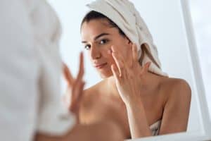 women applying acne treatment on her face