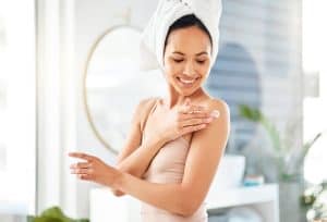 women applying cream on shoulder 