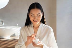  A happy woman trying an acne treatment