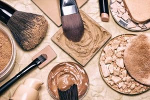 An image of a group of makeup powder containers and makeup brushes