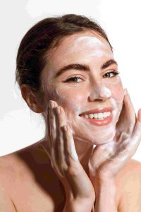 A photo of a woman applying an acne treatment to her face