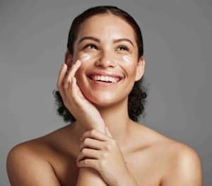 lady applying cream on her cheek