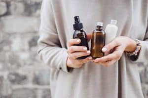 Woman holding three products in bottles in her hands