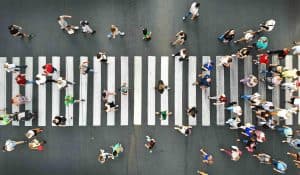 People crowd motion on pedestrian crosswalk. Top view from drone.