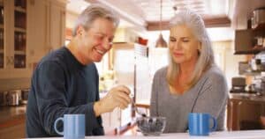 older couple sharing coffee and breakfast in the kitchen