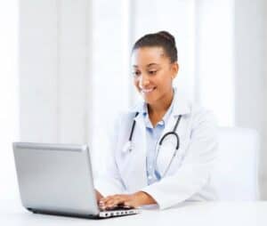 Black female doctor smiling at a laptop screen