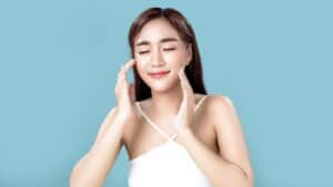 Woman with a large, content smile, showing radiant and glowing skin