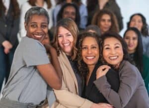 Diverse group of middle aged women hugging each other