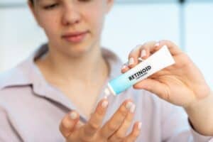 Women applying Retinoid (Tretinoin) Cream on the tip of her finger 