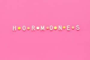 Word hormones on pink background