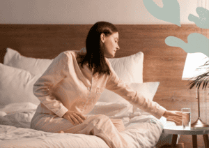 Woman taking a glass of water of her bedside table